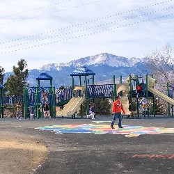 The outside playground at High Plains Elementary School with Pikes Peak in the background.