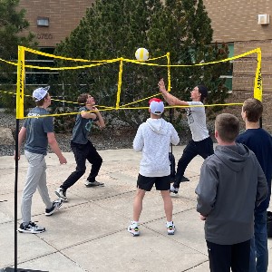 Group playing 4 square volleyball outside