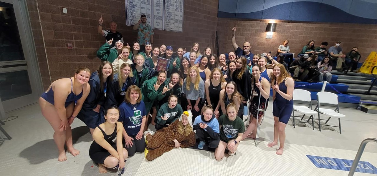 Swim team poses for photo after winning the CSML Championships