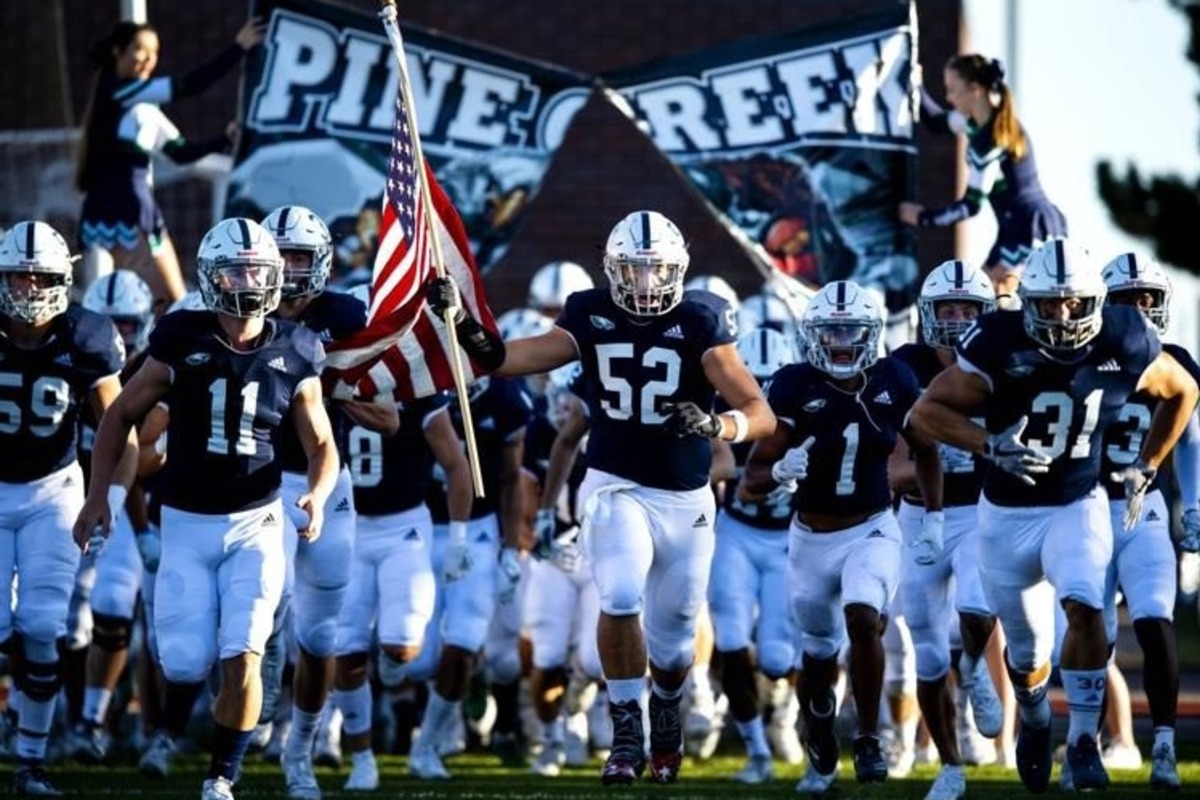 The PCHS football team carries the American flag onto the field during a game.
