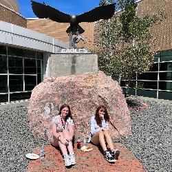 Two students in front of eagle statue