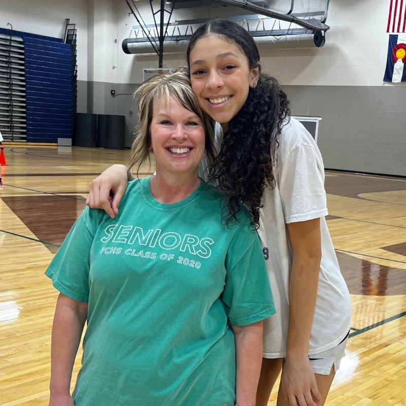 Student and Counseling secretary pose on the basketball court