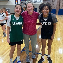 Students pose with Band director on the basketball court.