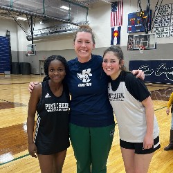 Students pose with PE teacher on basketball court