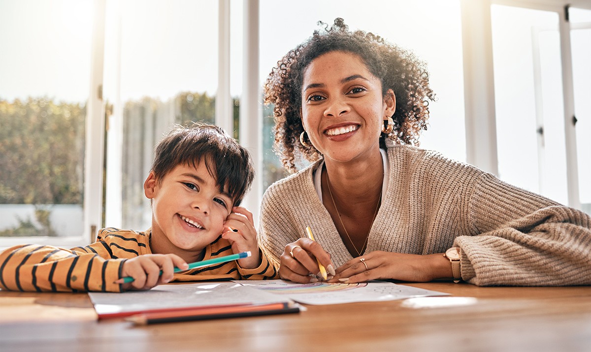 A homeschool student and his parent work at a desk.