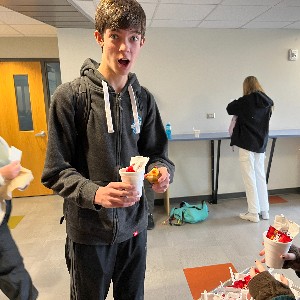 Student collects his cup of cocoa for receiving a duck by displaying kindness.