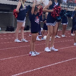 Liberty Cheerleaders guide young students in cheering during Liberty Football game. 
