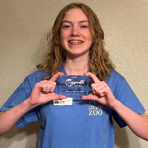 Liberty student Madison Revis holds up her Best and Brightest plaque while wearing her Cheyenne Mountain Junior Zookeeper shirt.