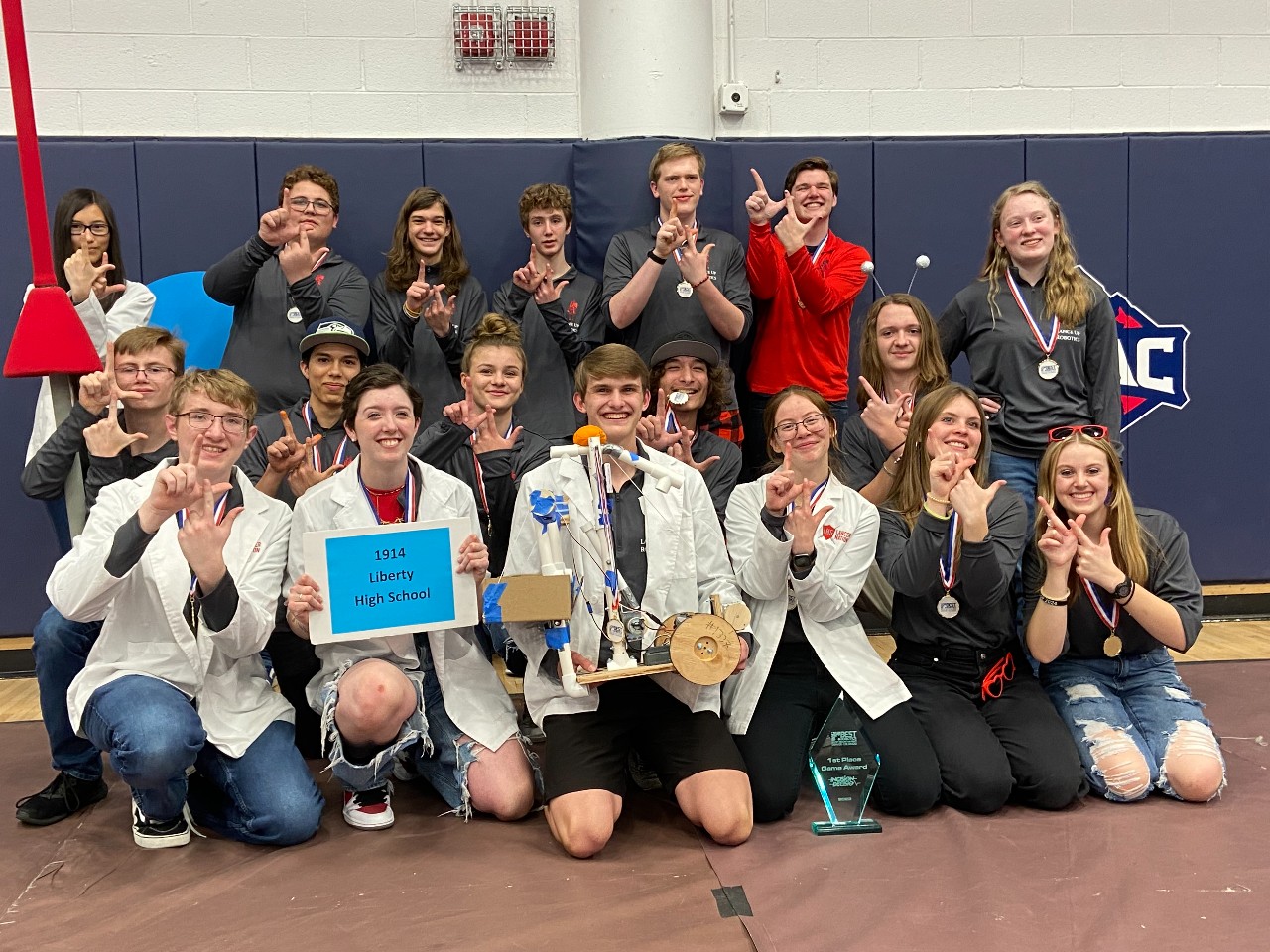 Liberty's Robotics teams poses for a picture with the double L hand gesture at their robotic competition on November 5th.
