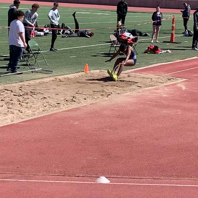 Athlete lands in the long jump pit