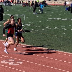 Girls running wit batons in the relay race