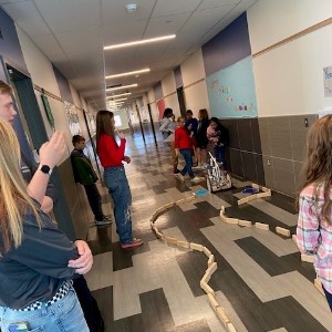 Liberty Robotics students and Legacy Peak Elementary test a robot in a hallway at Legacy Peak Elementary.