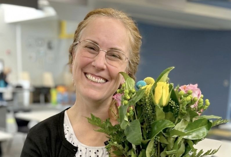 Air Academy High School assistant principal, Liz Walhof, sharing a genuine smile after receiving a bouquet of flowers after winning Administrator of the Year!