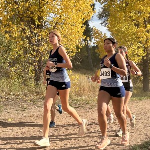 Girls running in front of yellow trees