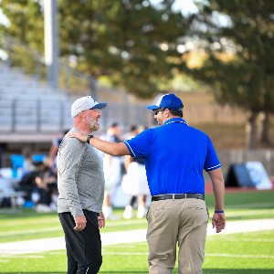 Two coaches laughing after game