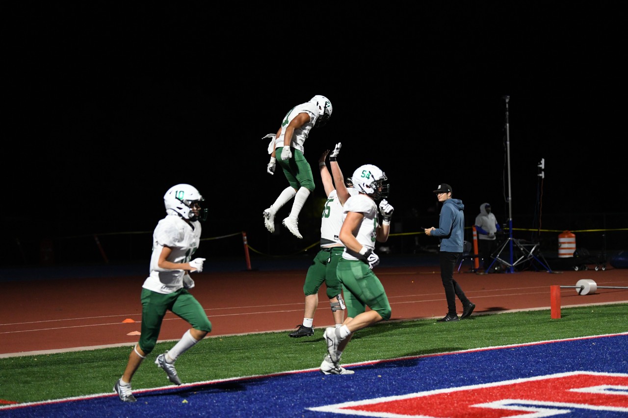 Player throws running back in the air in celebration of a touchdown