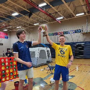 Liberty students hold a trophy in Liberty's gym during the Relay for Life.