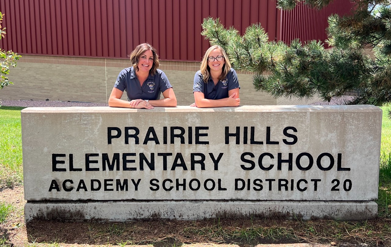 Ashley Livingstone and Susan Yoon pose about the PHES school sign.