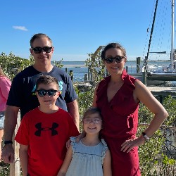 Assistant Principal Carrie Mitchell poses with her family near the ocean.