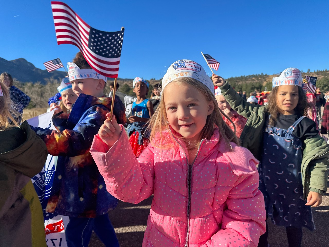 A girl holding a USA flag during the veteran's day parade