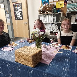 Students sitting at table with flowers and food