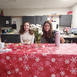 Students sitting at table with flowers and tea