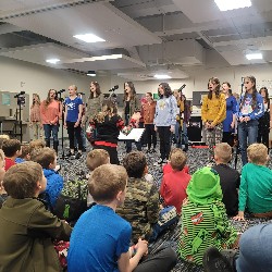 Older students performing for younger students