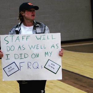 Student holding sign that says, "Staff will do as well as I did on my FRQs."