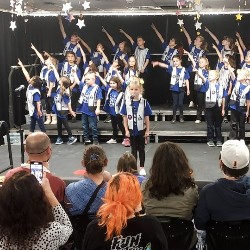 Students singing and dancing on stage.