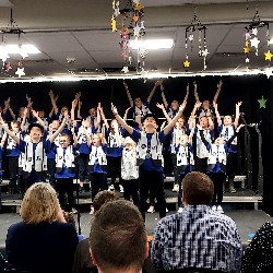 Students singing and dancing on stage.