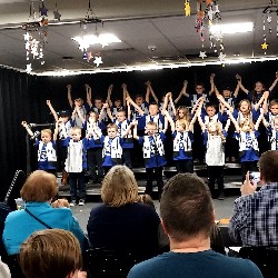 Students singing and dancing on stage.