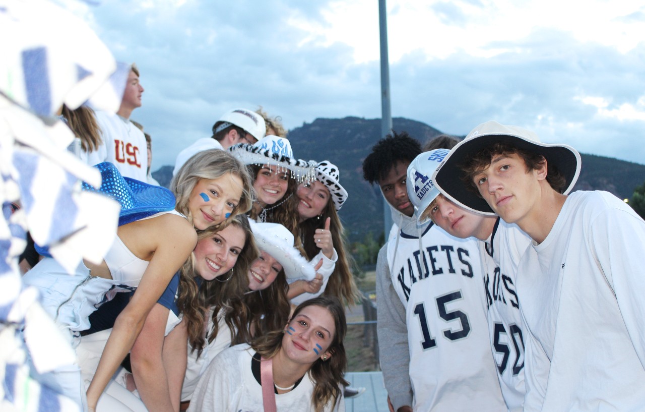 AAHS students pose together in white jerseys during a school athletics event.