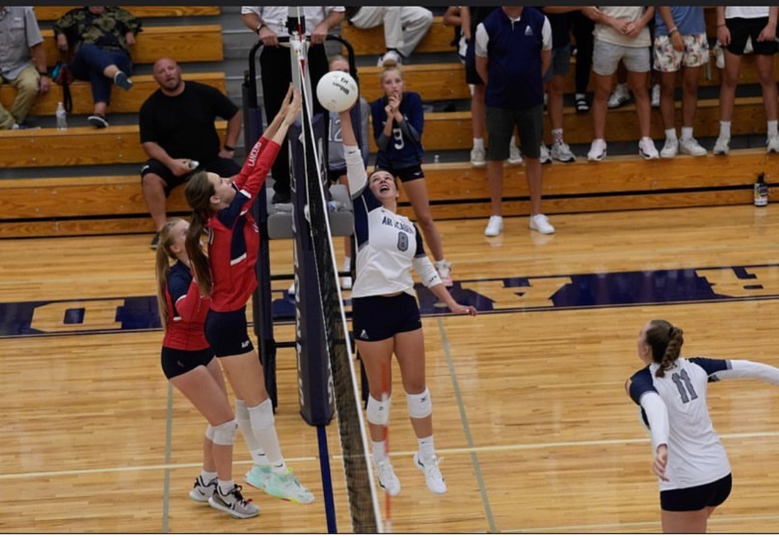 An AAHS Volleyball player hits the ball across the net at a game.