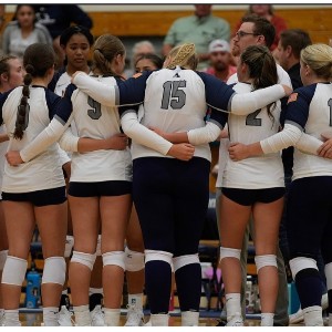 The AAHS volleyball team huddles during a game.