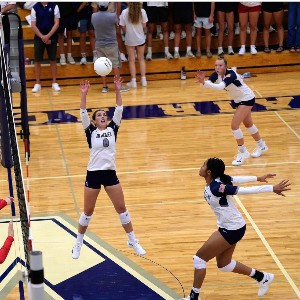 Two AAHS volleyball players work in tandem to return the ball across the net.
